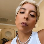 A photo of Lourysela, who is wearing a white tank top.