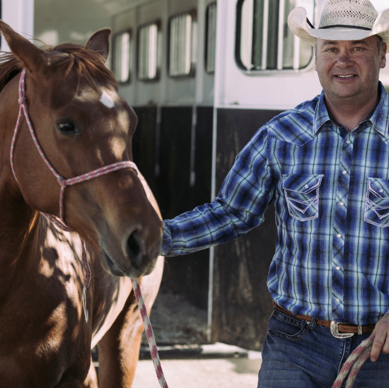 A picture of volunteer Doug petting a horse 